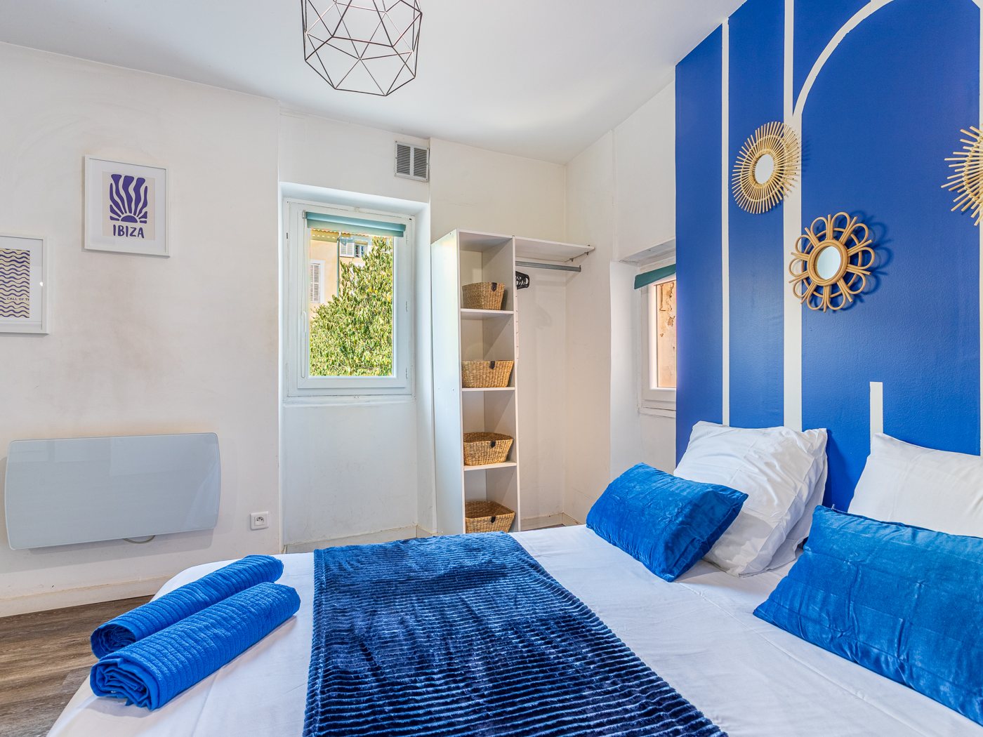 Après home staging : chambre au mur bleu du studio Escale bleue à Hyères