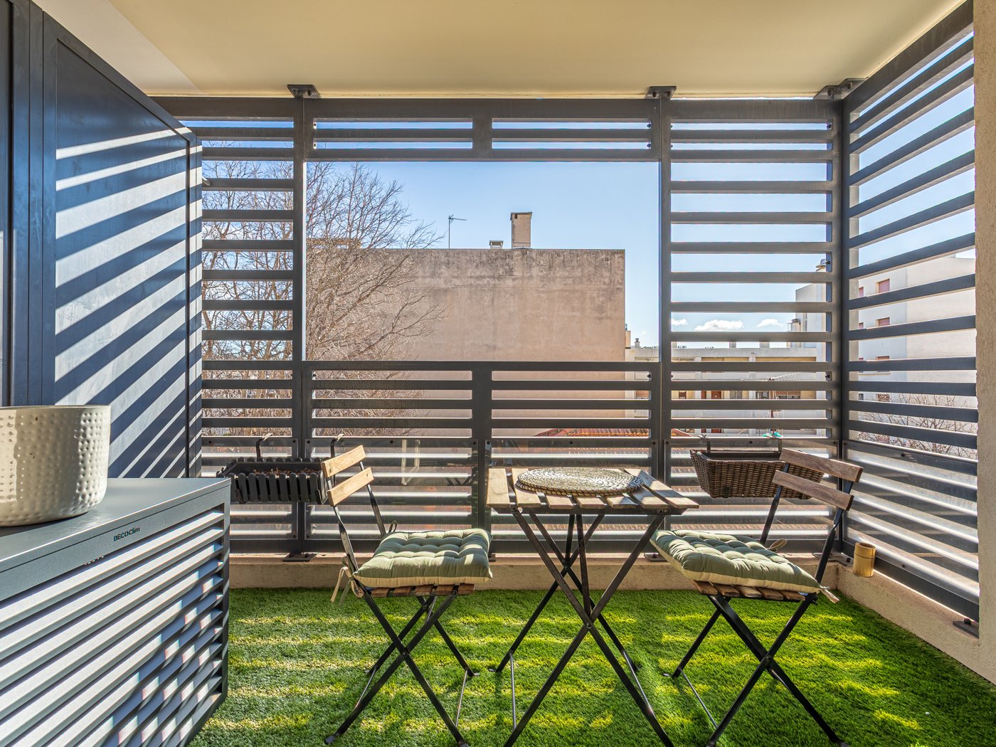 Terrasse aménagée du T2 Carré Mermoz, gazon et salon de jardin